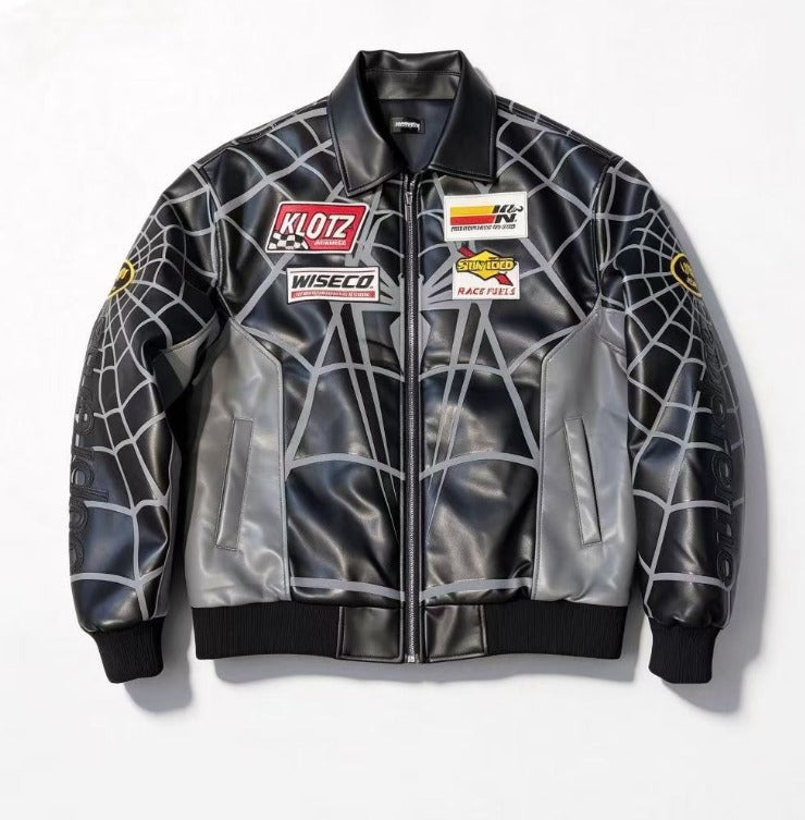 A black and gray spiderweb-patterned leather jacket with sponsor patches on the chest, displayed flat against a white background.
