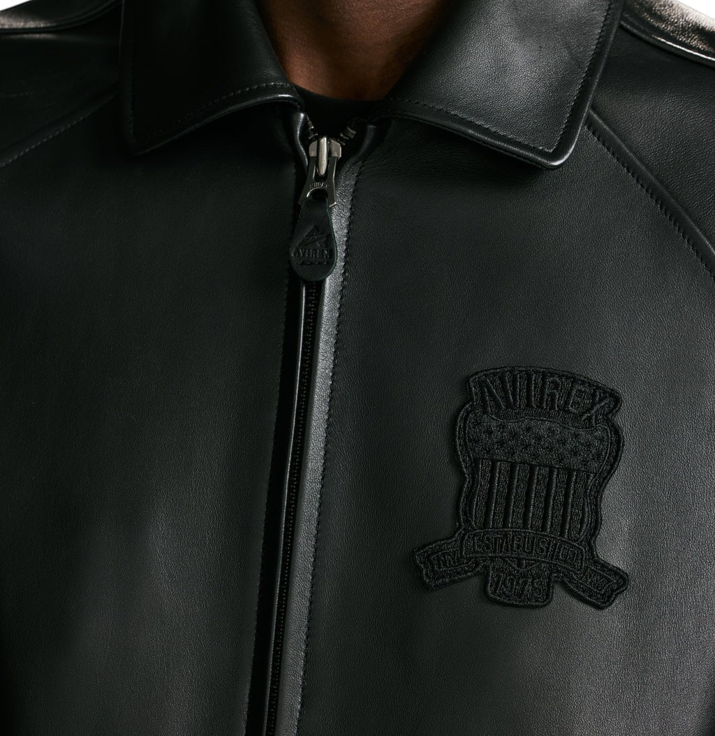 OFFCODE.USA Avirex black antique lamb leather bomber jacket with logo patch and zip closure.