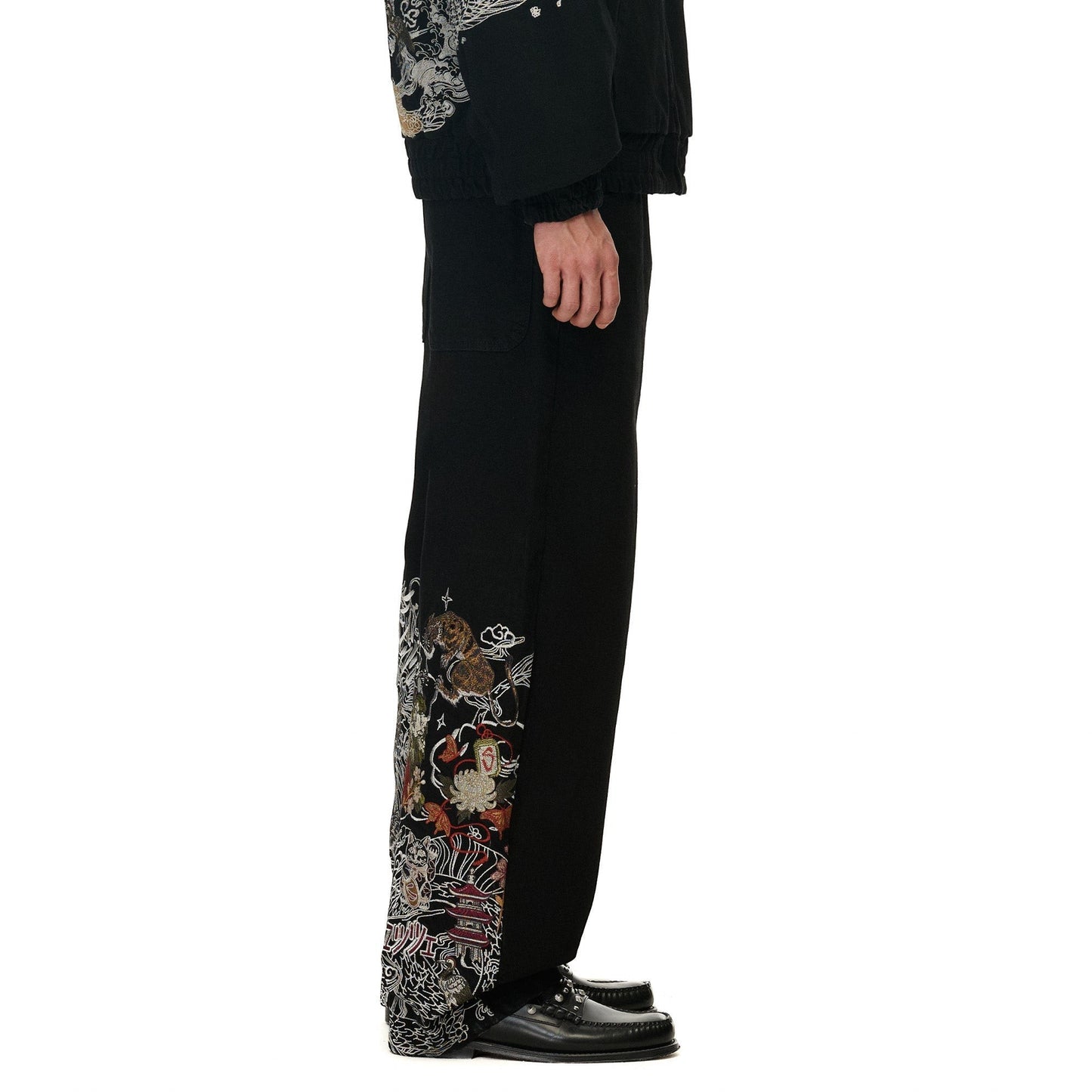 OFFCODE.USA black denim balloon fit pants with intricate yakuza-style embroidery on the side.