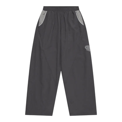 OFFCODE.USA grey nylon track pants with white 3D piping, applique mesh logo, and ankle toggles.