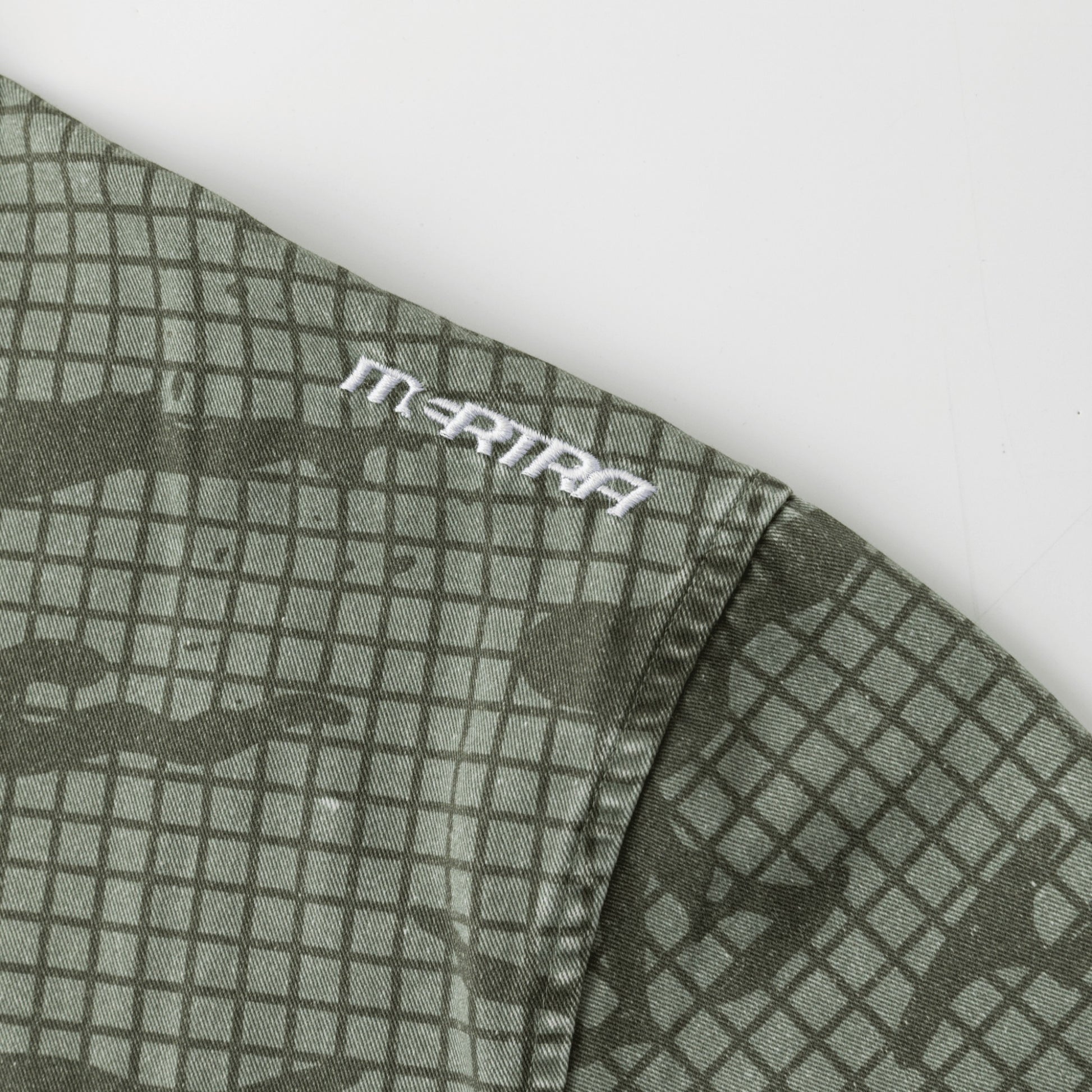 OFFCODE.USA green cotton grid camo shirt with embroidered logo on sleeve and tortoise shell button detail.