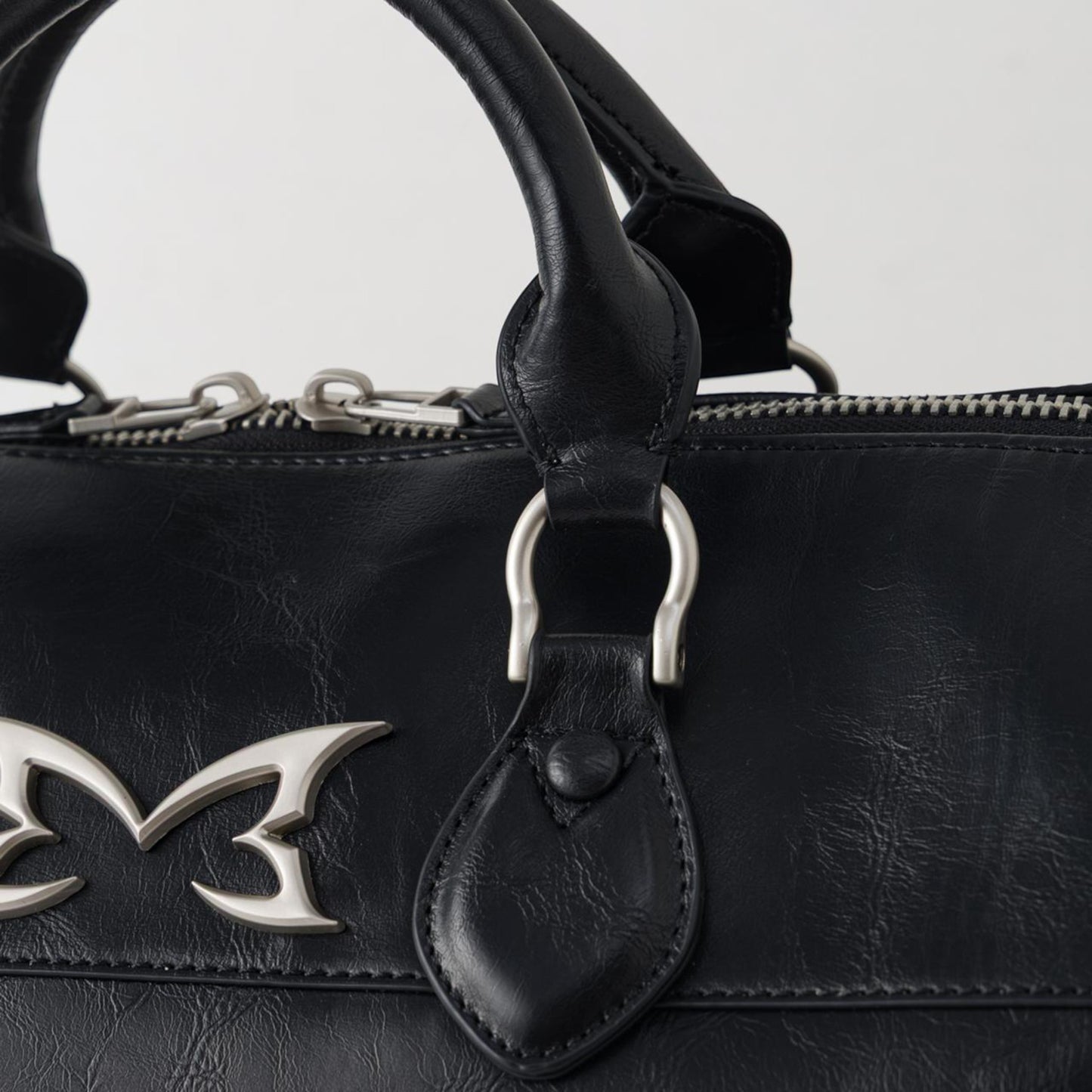 OFFCODE.USA MERTRA x Slawn Duffle bag in black PU leather with silver metal icon logos and debossed graphics.