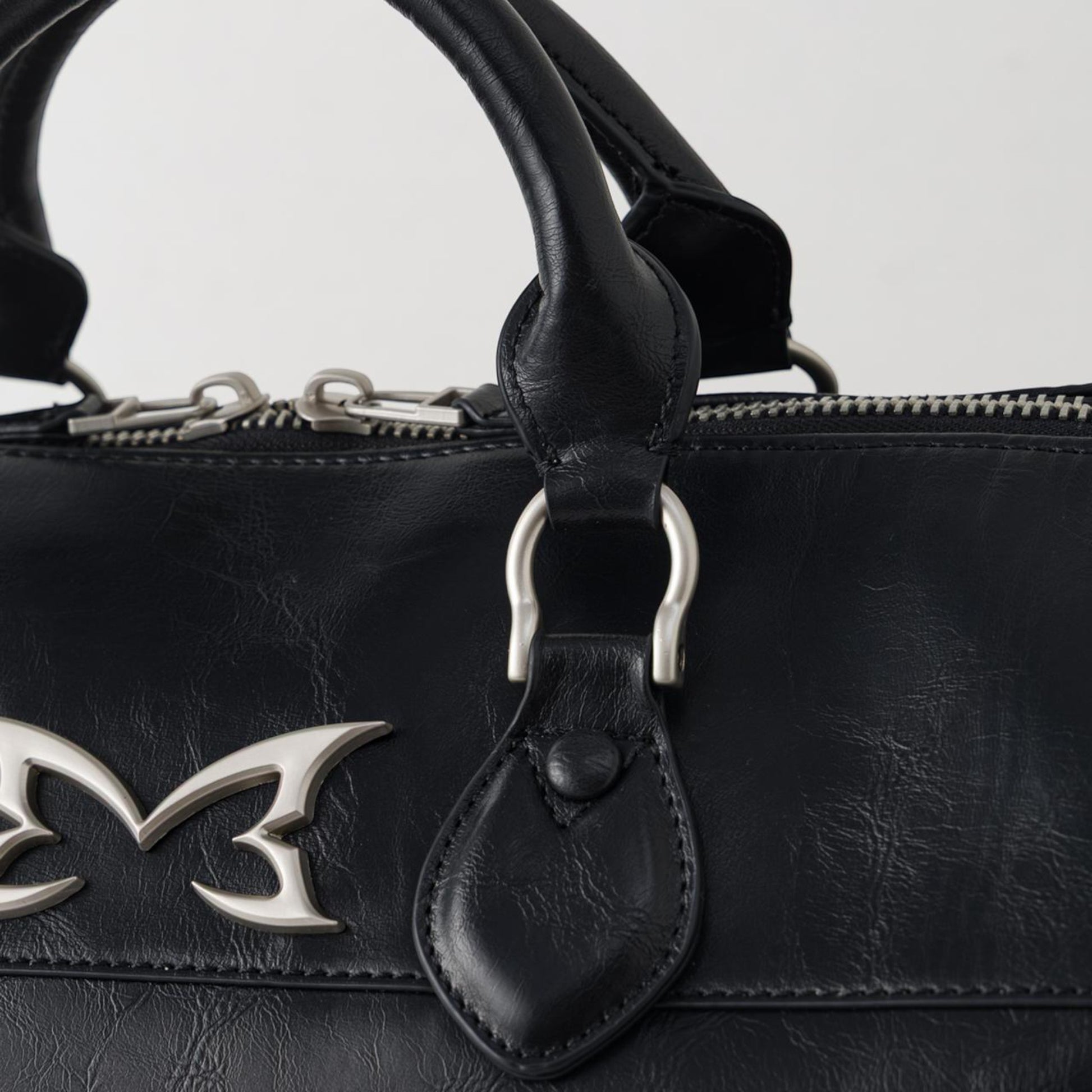 OFFCODE.USA MERTRA x Slawn Duffle bag in black PU leather with silver metal icon logos and debossed graphics.