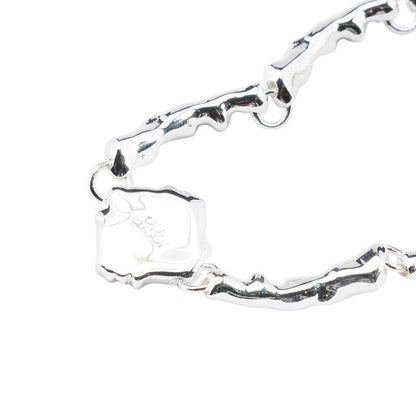 OFFCODE.USA silver and gold plated brass splash bracelet with unique organic links and a charm.