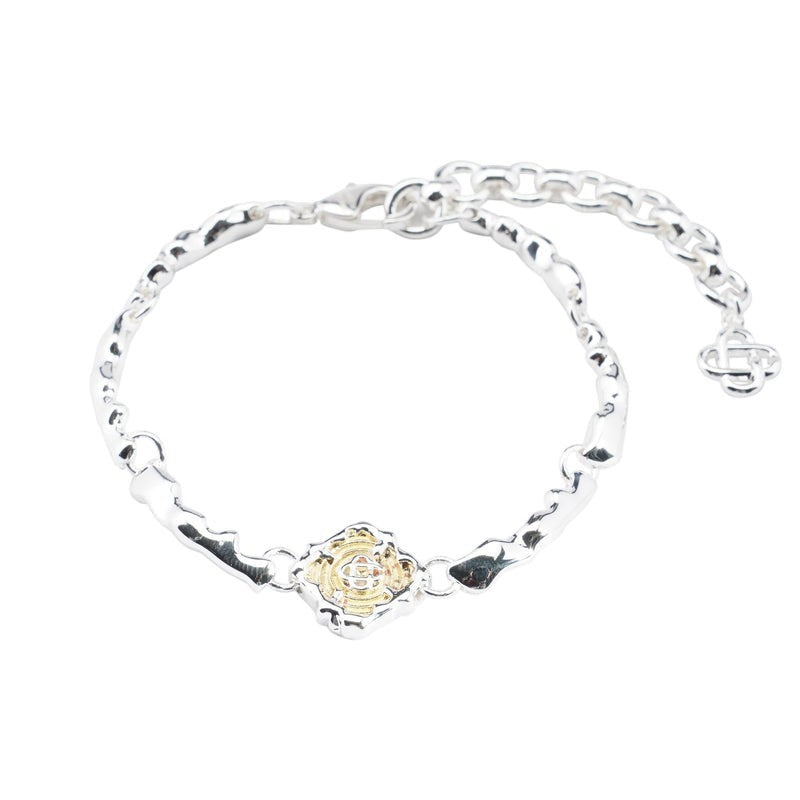 OFFCODE.USA silver and gold splash bracelet with a central gold-plated brass charm. Adjustable chain.