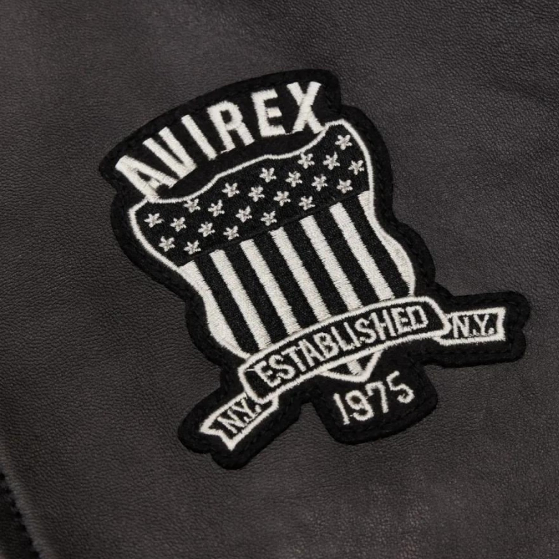 OFFCODE.USA Trapstar X Avirex Icon Leather Jacket - Black. Features embroidered shield patch with "AVIREX ESTABLISHED 1975 NY".