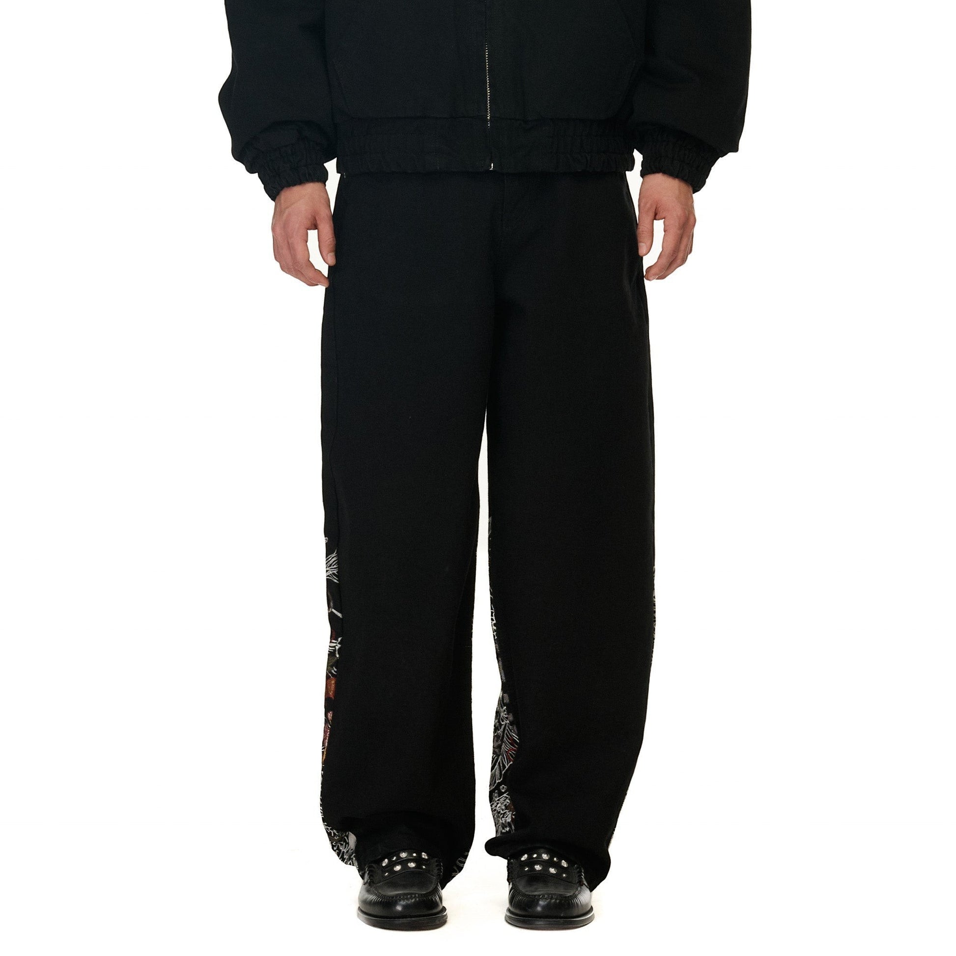 OFFCODE.USA black denim balloon fit jeans with intricate embroidery on the side seams. Made from 100% cotton.