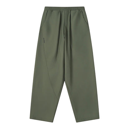 OFFCODE.USA olive green tech joggers with asymmetrical paneling, reflective logos, and wide leg fit.