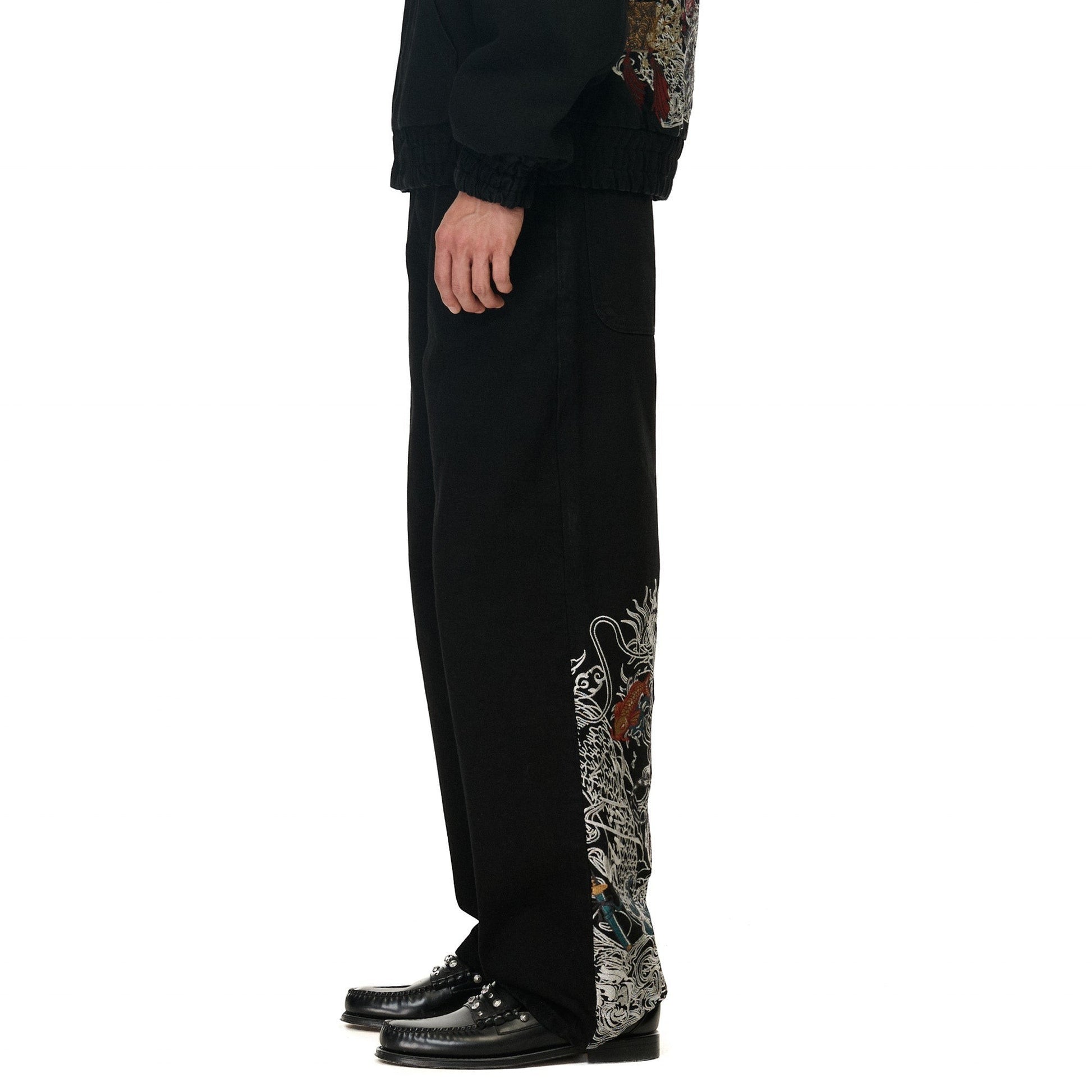 OFFCODE.USA black denim balloon fit jeans with intricate dragon embroidery on the side.