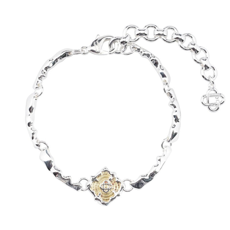 OFFCODE.USA silver and gold splash bracelet with textured links and a central gold-plated brass charm.