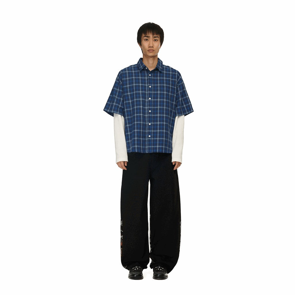 OFFCODE.USA black denim jeans with intricate embroidery and balloon fit, worn by a male model.