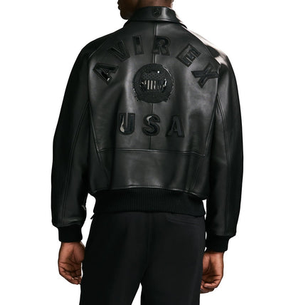 OFFCODE.USA black leather bomber jacket with "AVIREX USA" logo detail on back. Ribbed hem and cuffs.