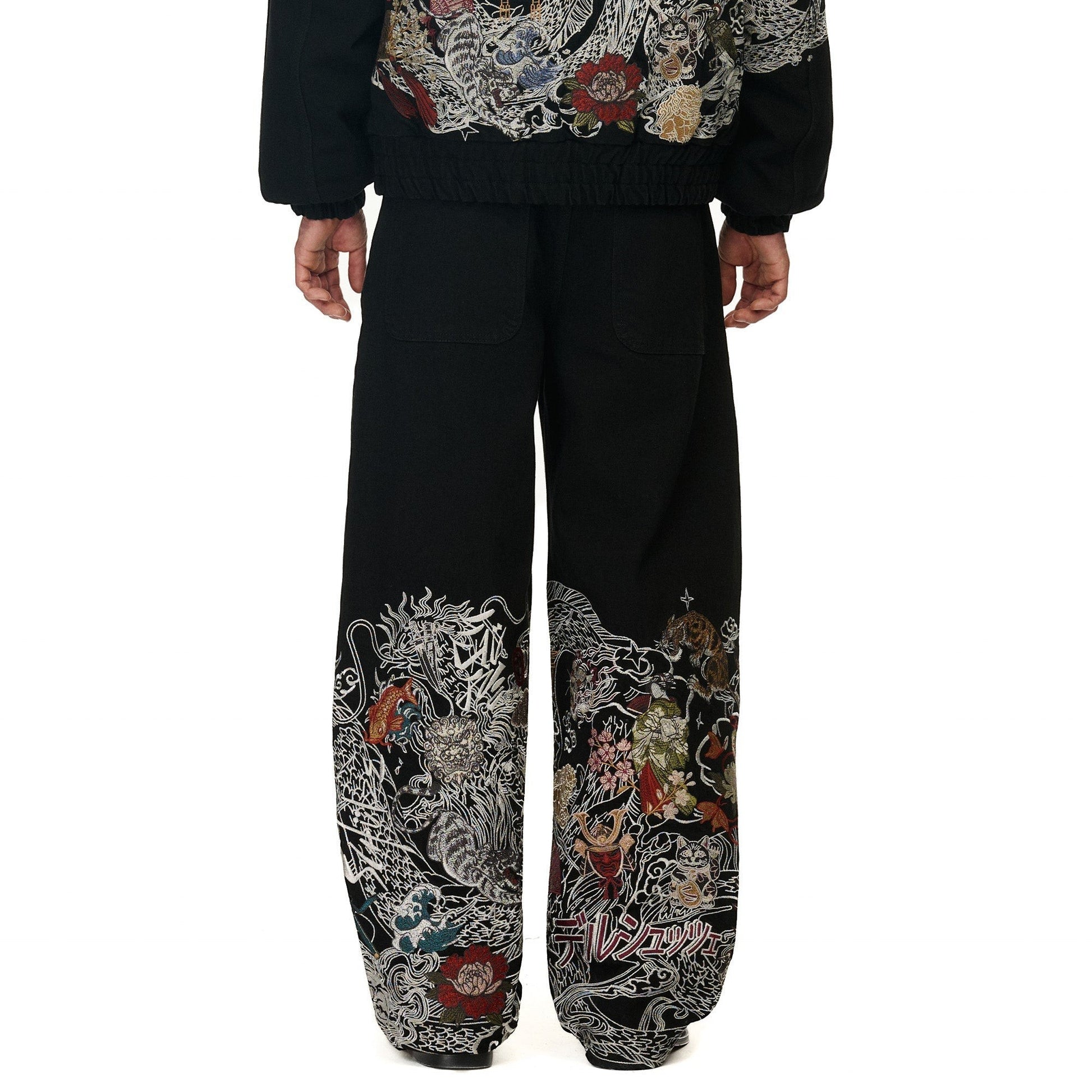 OFFCODE.USA black denim balloon fit pants with intricate Japanese-style dragon and floral embroidery on the lower legs.
