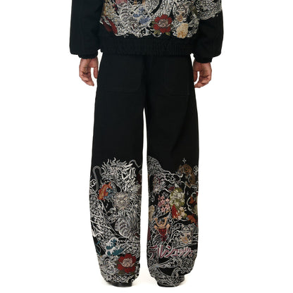 OFFCODE.USA black denim balloon fit pants with intricate Japanese-style dragon and floral embroidery on the lower legs.